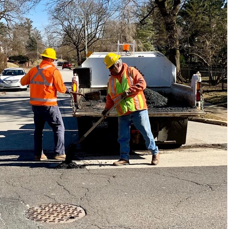 Public Works employees filling in road potholes