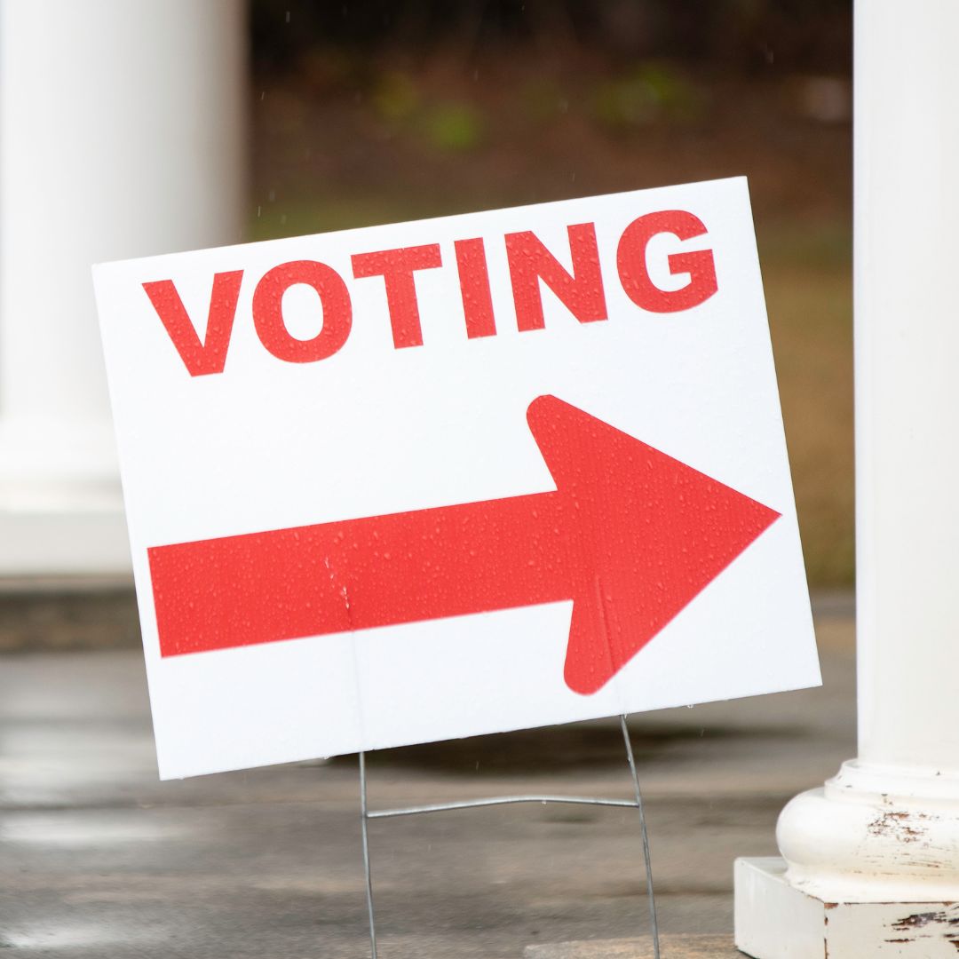 Sign that says voting with a red arrow